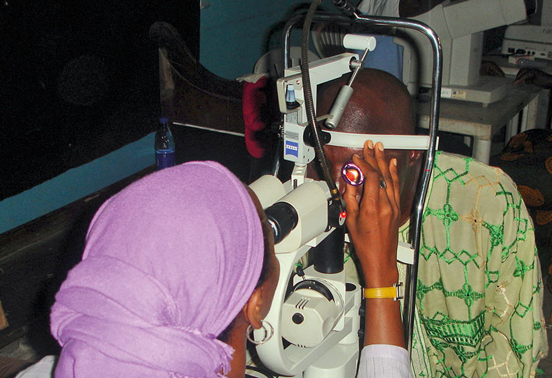 a female ophthalmologist examines the eye of a male patient at the slit lamp