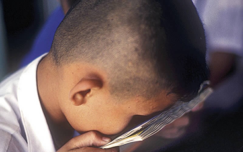 Many children with low vision are able to read by using their strong ability to focus on near objects (accommodation). THAILAND. © Clare Gilbert