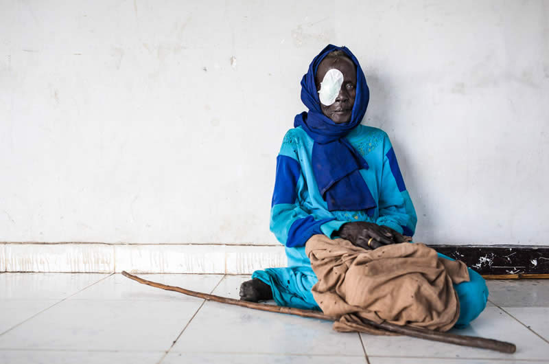 A woman rests in the hallway after her cataract operation, conducted at a clinic in South Sudan as part of an outreach programme. Adriane Ohanesian/Sightsavers