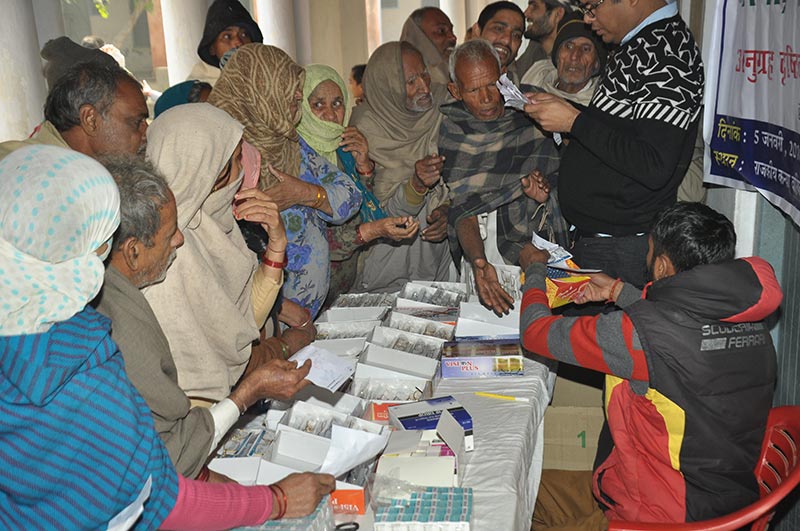 Elderly villagers crowding around a table of spectacles