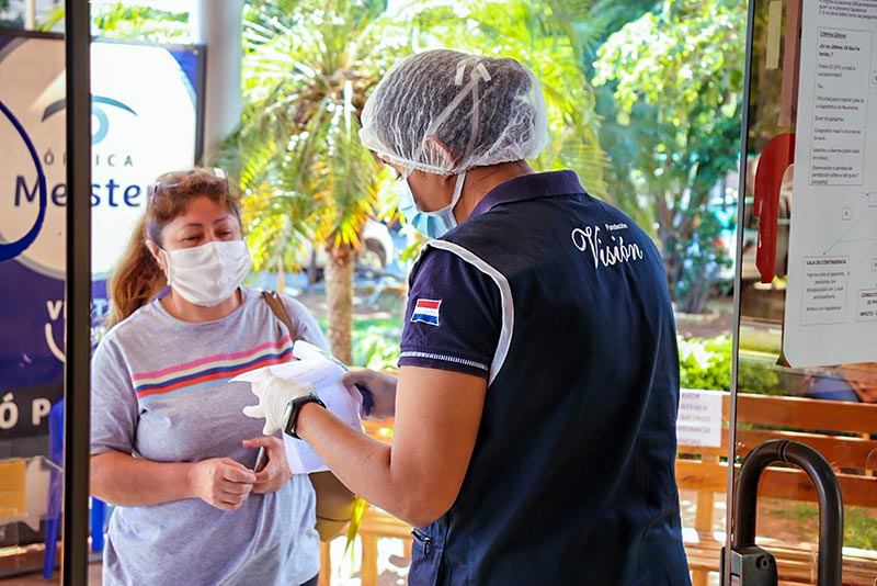 Health worker check paperwork with a patient at the entrance to the clinic