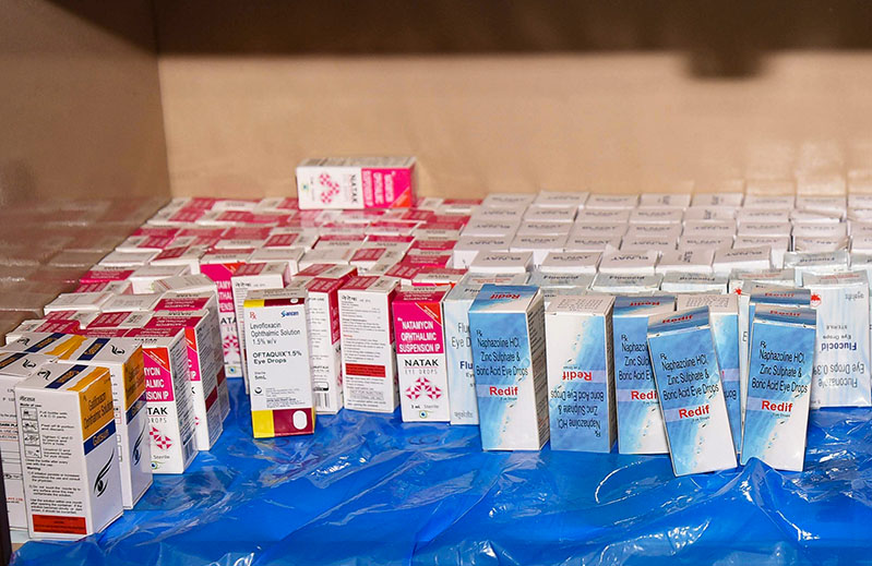 Many bottles of different eye drops on a shel